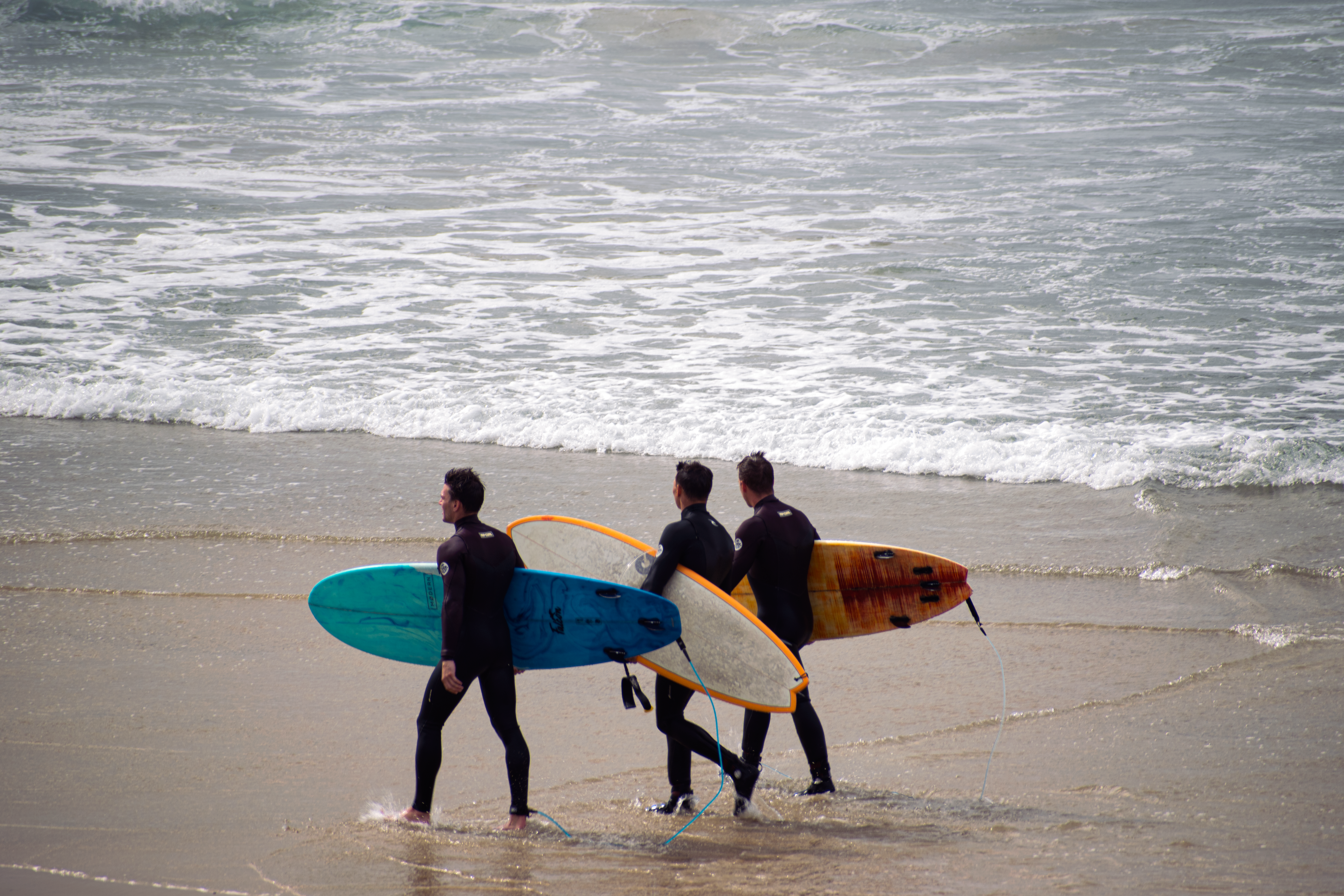 A photo of surfer dudes on the beach.